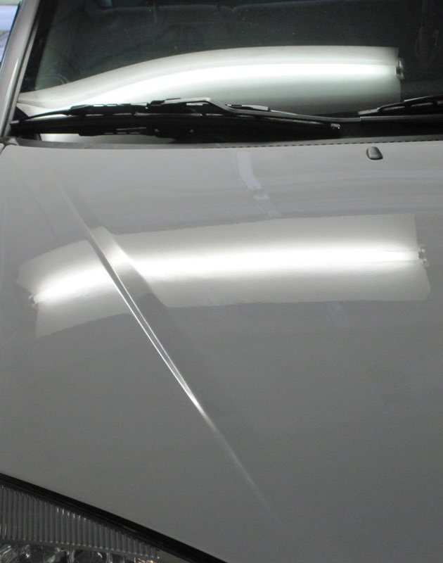 Same hood and fender smooth after paintless dent repair