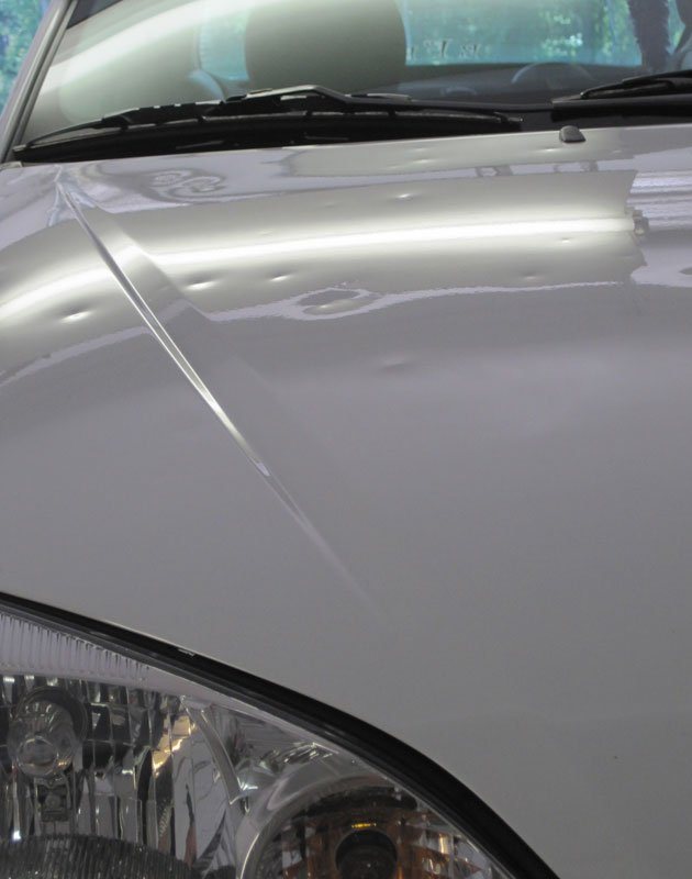 Hood and fender with hail dents before repair
