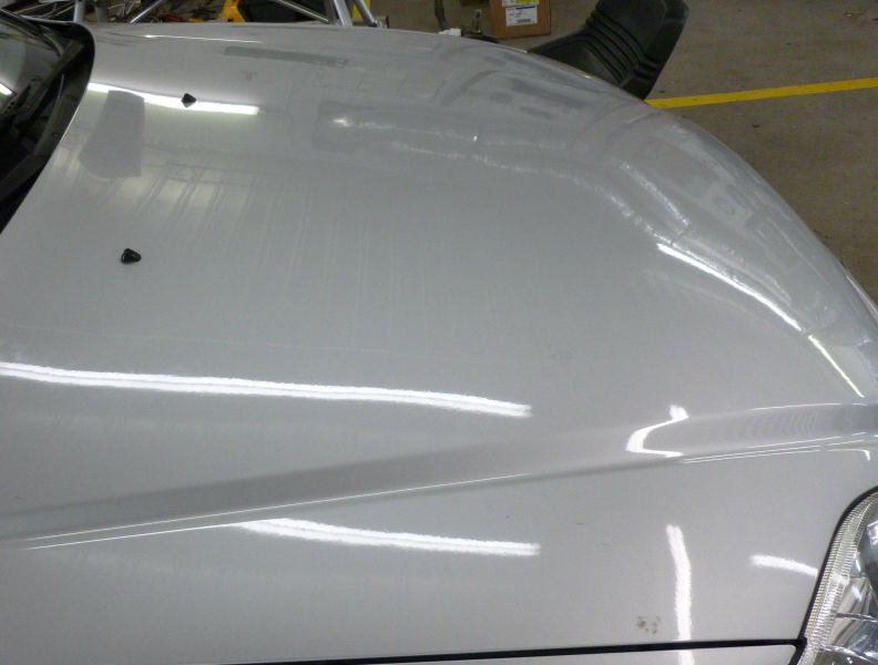 Same hood after paintless dent repair, factory finish restored