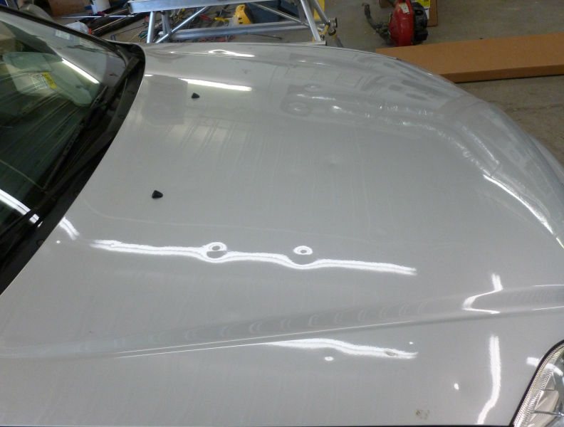 Hood covered in hail dents before paintless dent repair