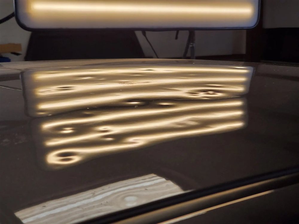 Roof panel showing dozens of hail dents under PDR inspection light