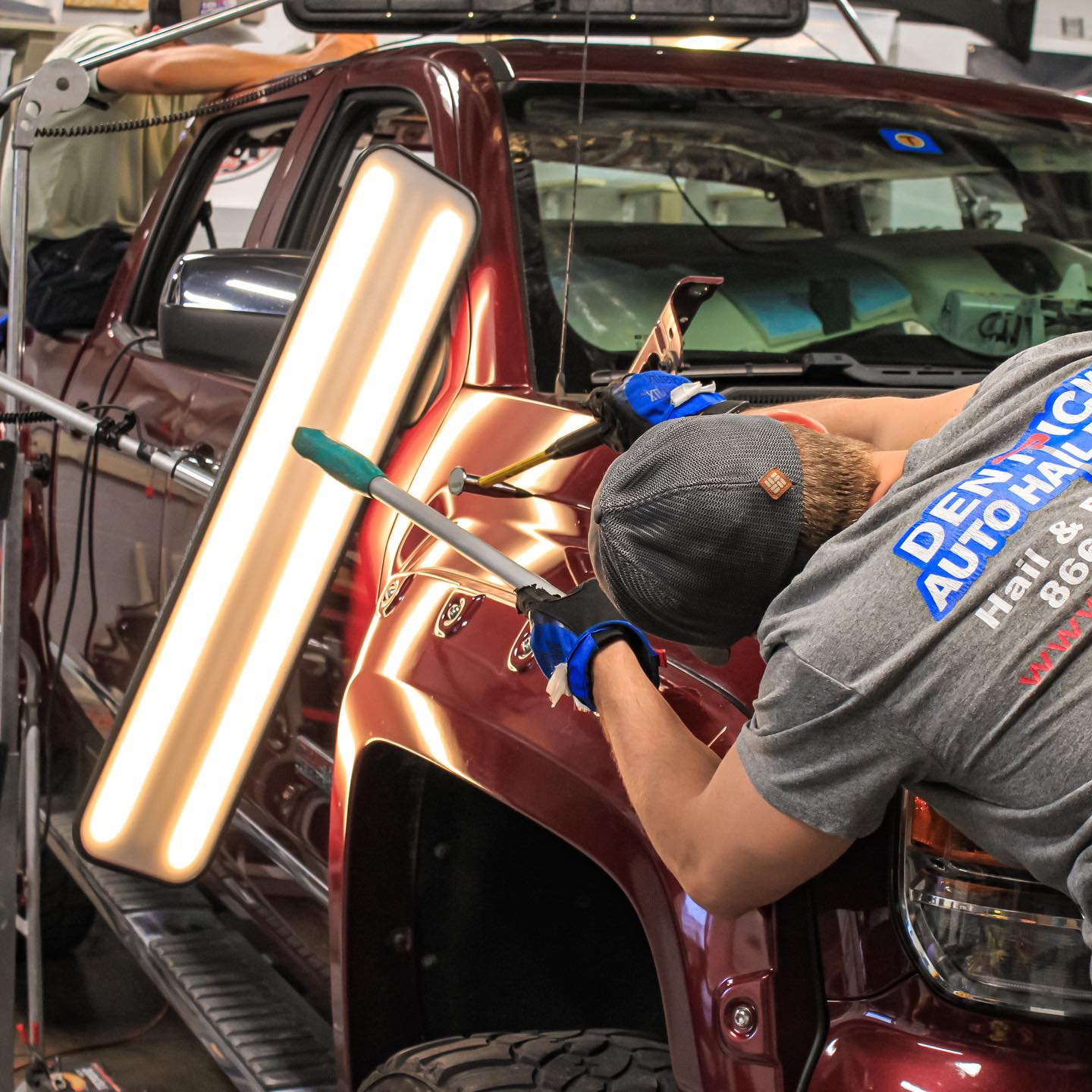 DentPicks technician performing paintless dent repair on a hail-damaged truck at the Plano, TX shop